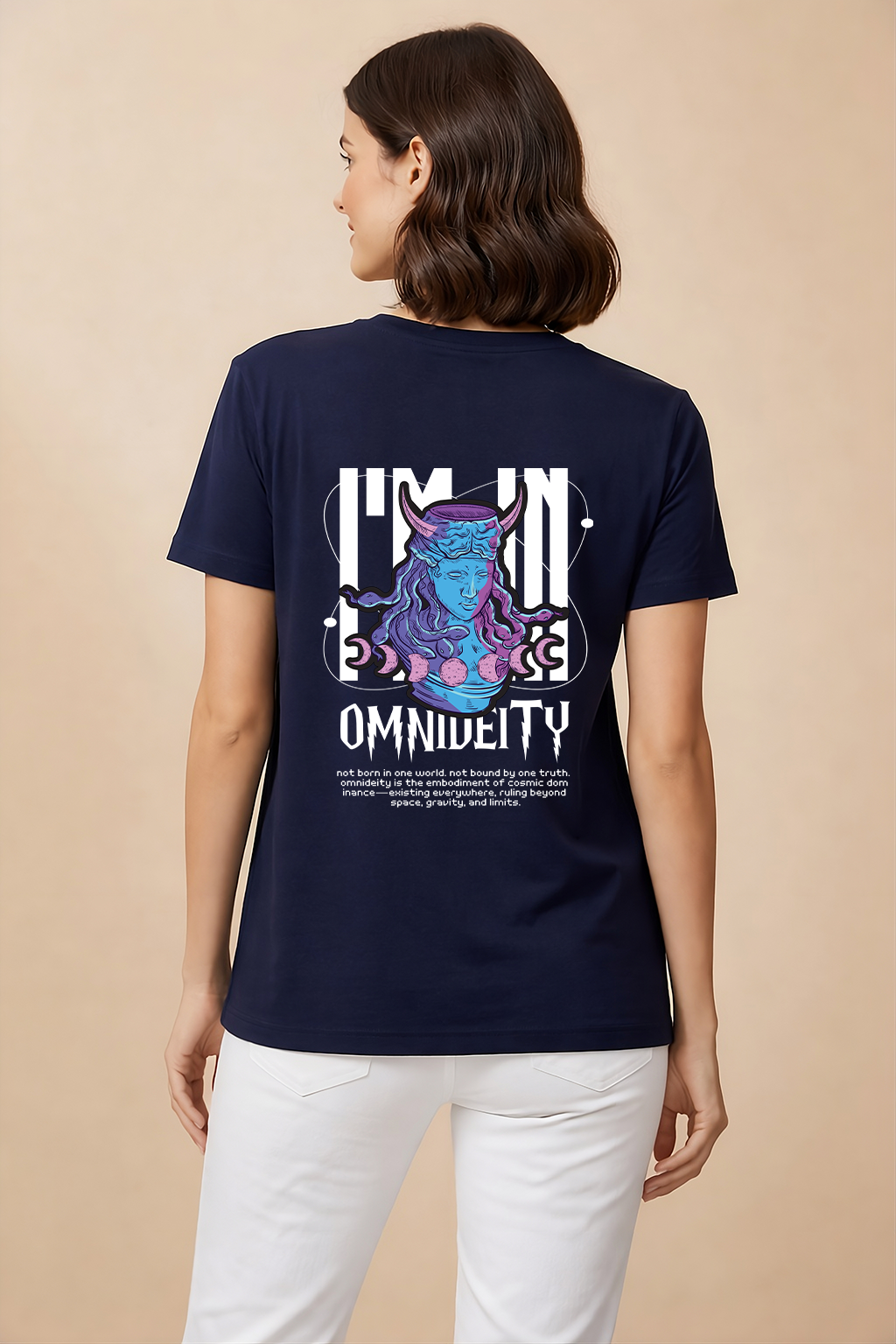 Lady wearing a Navy blue t-shirt with a graphic and text on the back, standing against a beige background.